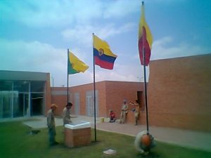 tres astas para exterior con sus respectivas banderas instaladas en el patio de un colegio