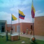 tres astas para exterior con sus respectivas banderas instaladas en el patio de un colegio